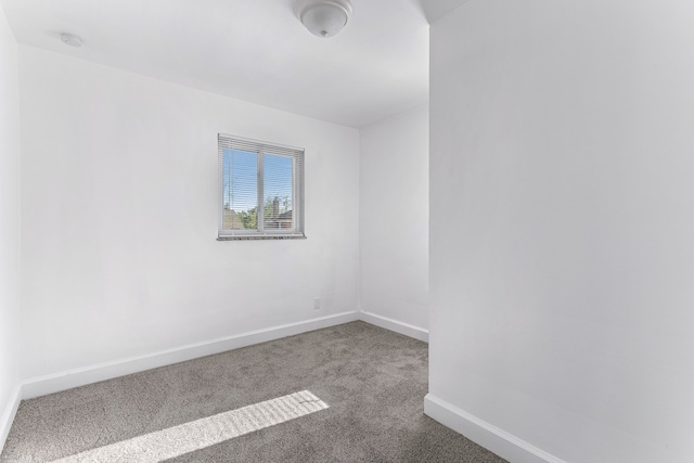 unfurnished room featuring carpet flooring and baseboards