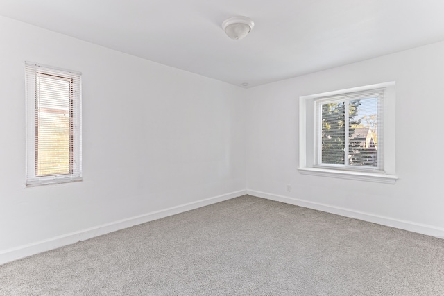 spare room featuring carpet flooring and baseboards