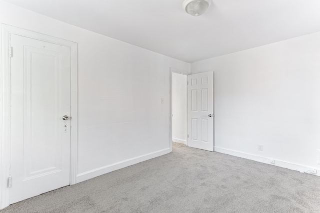 carpeted empty room with baseboards