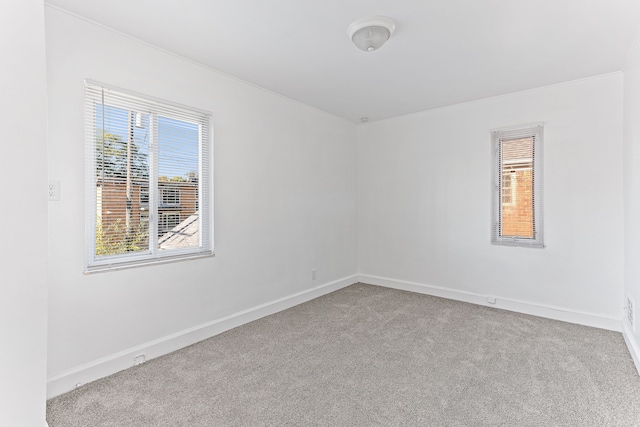 empty room with baseboards and light colored carpet