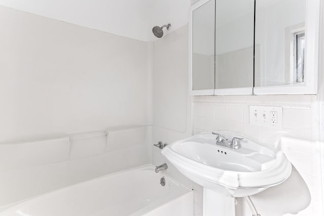 full bathroom featuring tasteful backsplash, tub / shower combination, and a sink