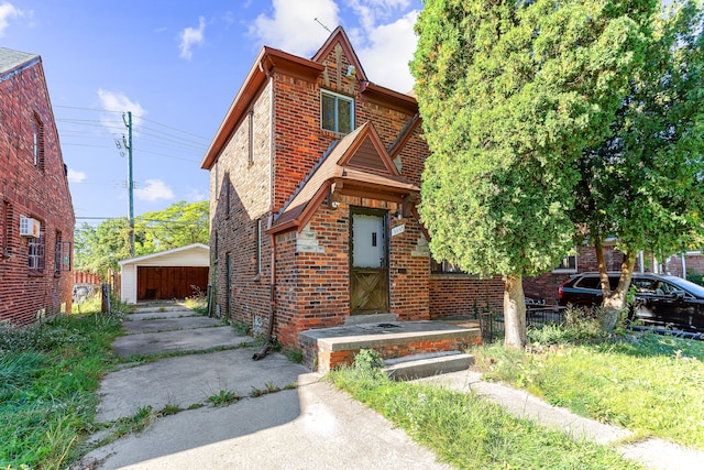 view of front of home with an outbuilding and brick siding