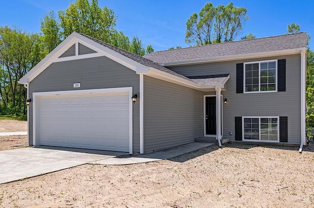 view of front of house with a garage, a shingled roof, and concrete driveway