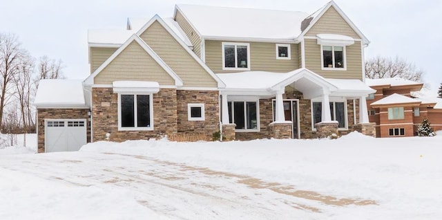 craftsman inspired home with an attached garage and stone siding