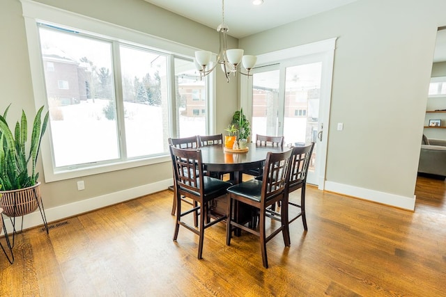 dining space featuring dark wood-style floors, plenty of natural light, visible vents, and baseboards