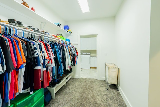 walk in closet with washing machine and dryer and light colored carpet