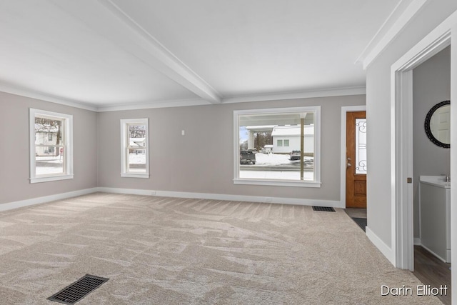 unfurnished room with plenty of natural light, baseboards, visible vents, and light colored carpet