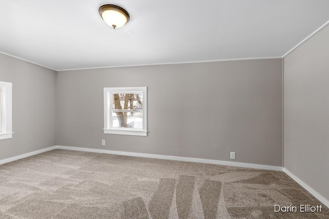 empty room with carpet floors, baseboards, and crown molding