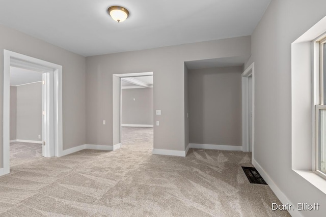 unfurnished room featuring light carpet, baseboards, and visible vents