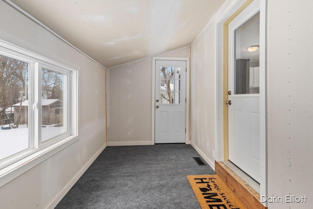 interior space featuring lofted ceiling, baseboards, dark carpet, and a wealth of natural light