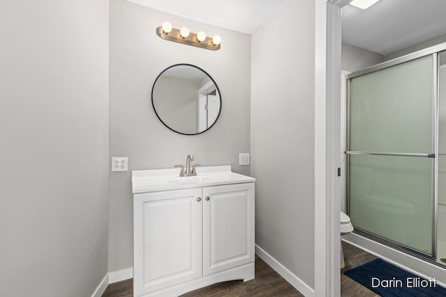 bathroom featuring baseboards, toilet, and wood finished floors