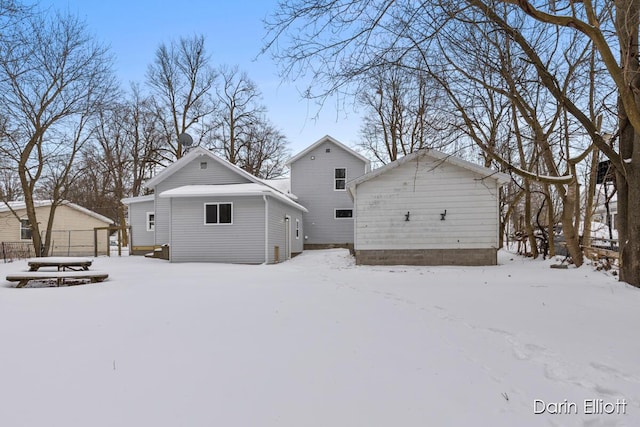 snow covered house featuring a detached garage