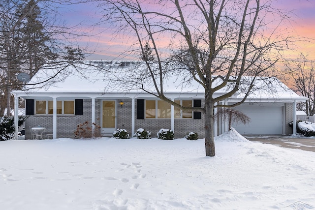 single story home with entry steps, a garage, and brick siding