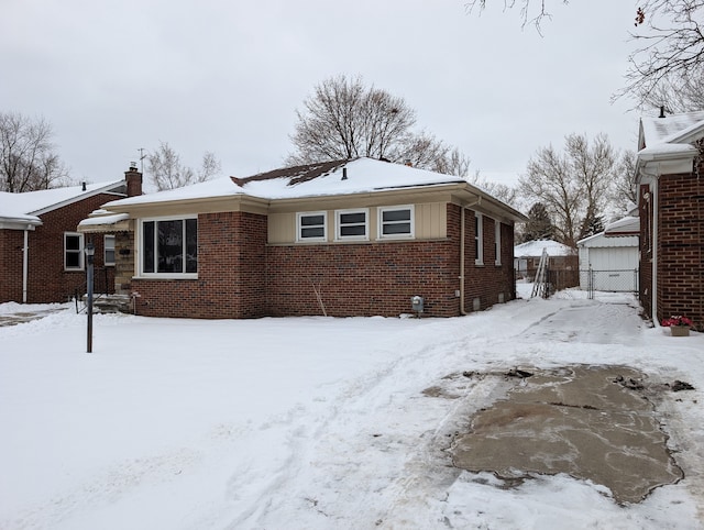 exterior space with a garage, brick siding, and fence