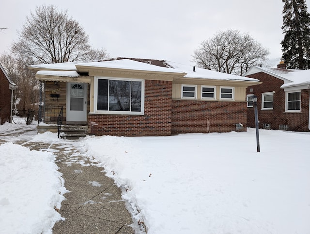 bungalow featuring brick siding