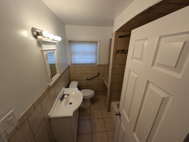 full bathroom featuring toilet, a wainscoted wall, tile patterned flooring, vanity, and tile walls