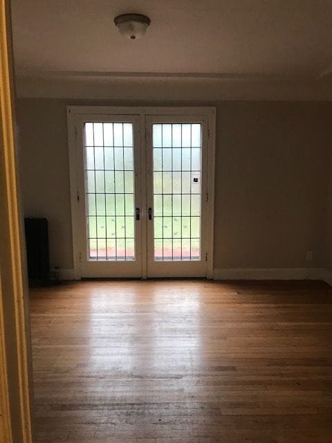 doorway to outside featuring baseboards and wood finished floors