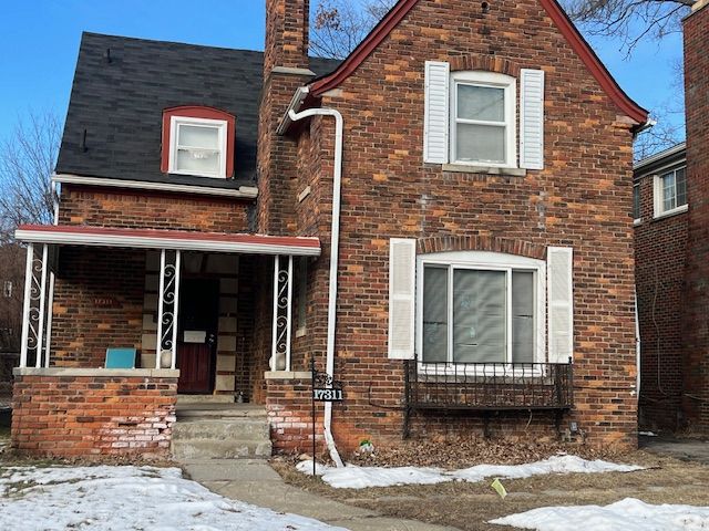 view of front of home with covered porch and brick siding