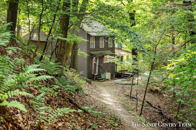 view of property exterior with entry steps, roof with shingles, and central air condition unit