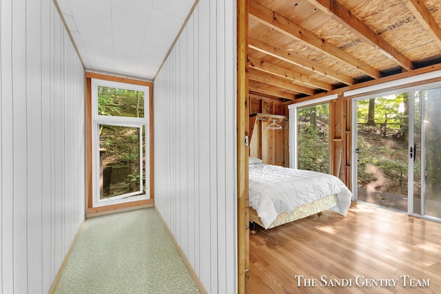 bedroom featuring access to outside and wood walls