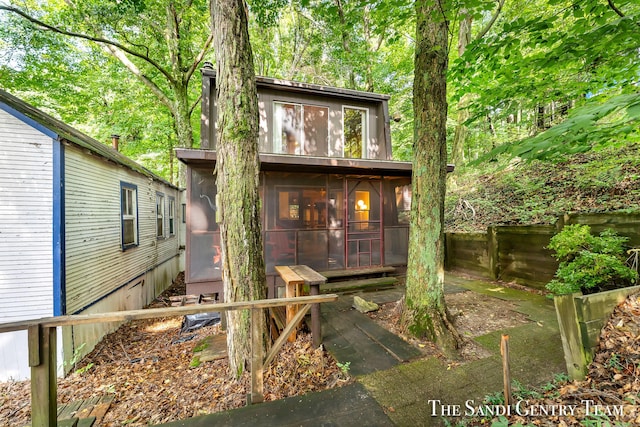 view of front of property with a sunroom and fence