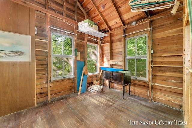 interior space with dark wood-type flooring, wood walls, and wooden ceiling