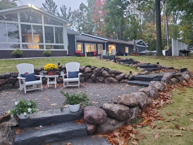 rear view of house with a sunroom and a yard