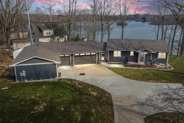 9356 Miramichi Dr, Evart, MI 49631 - view of front of property featuring a water view, a porch, concrete driveway, a garage, and a front yard