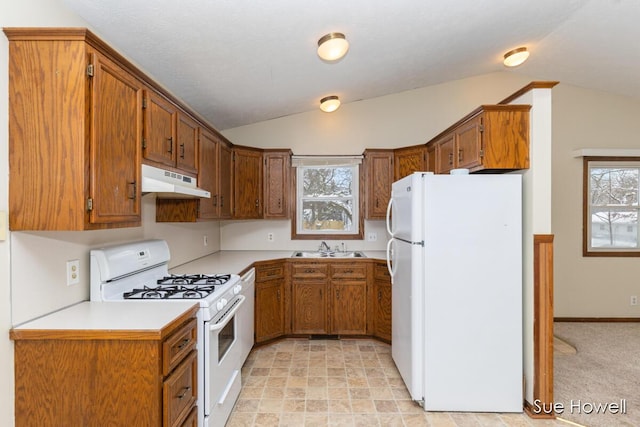 kitchen featuring under cabinet range hood, white appliances, a sink, light countertops, and brown cabinets