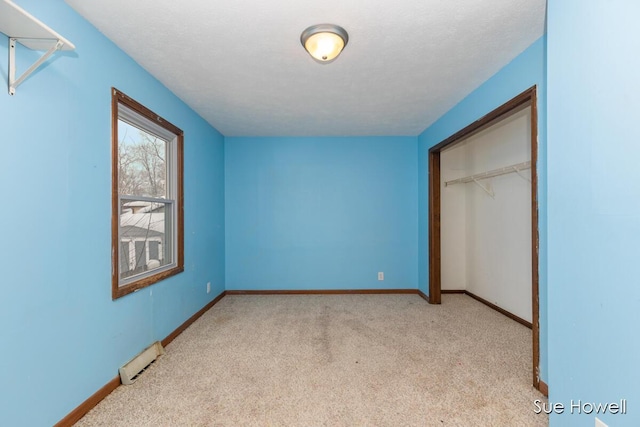 unfurnished bedroom with a baseboard radiator, baseboards, and light colored carpet