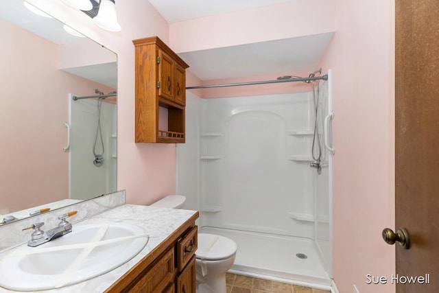 full bath featuring a stall shower, vanity, and toilet