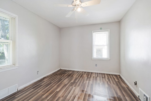 unfurnished room with dark wood-style floors, baseboards, and visible vents