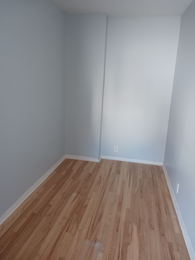 unfurnished room with light wood-style flooring and baseboards