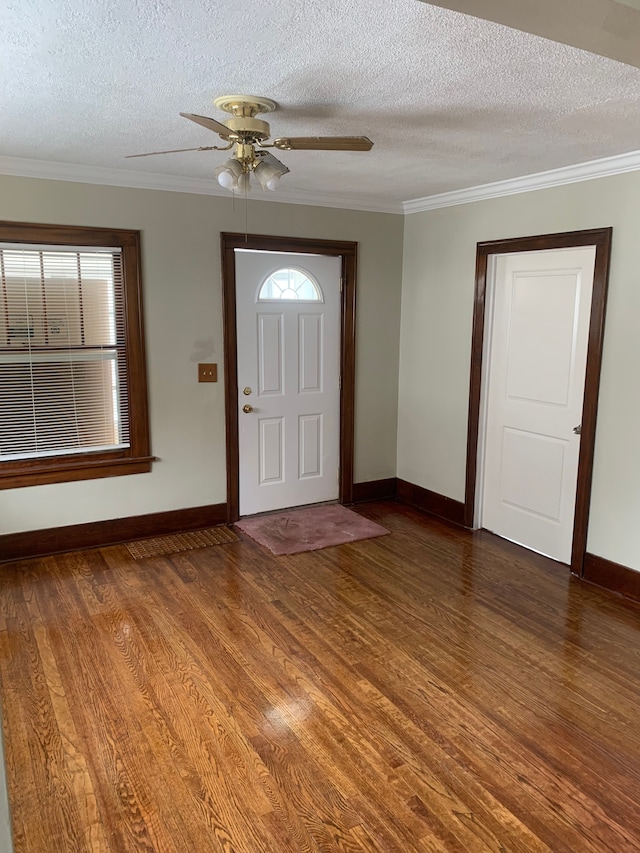 entrance foyer featuring baseboards, a textured ceiling, wood finished floors, ornamental molding, and ceiling fan