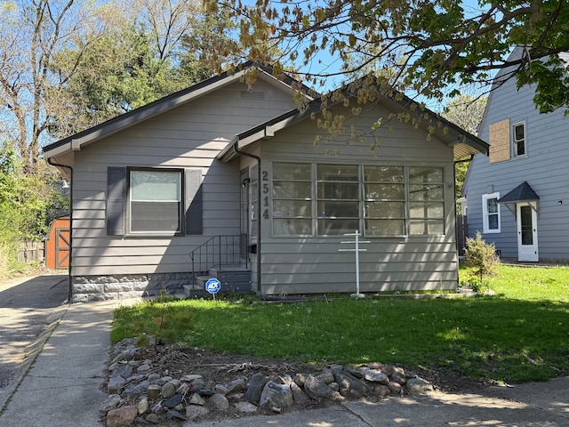 view of front of home featuring a front yard and a sunroom