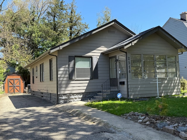 view of front of house with a storage shed and an outdoor structure