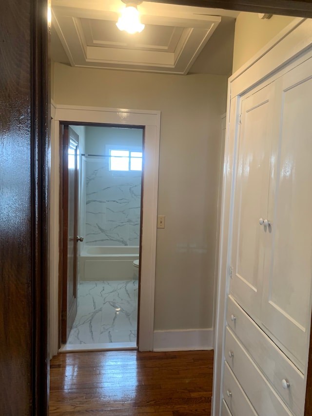 hall with wood-type flooring and baseboards