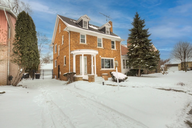 view of front facade with fence and brick siding