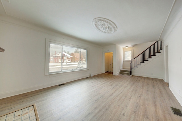 9543 W Outer Dr, Detroit, MI 48223 - unfurnished living room featuring stairs, visible vents, and light wood-style flooring