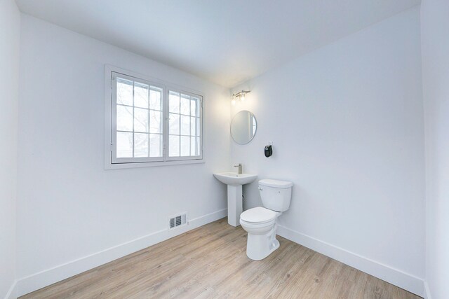 9543 W Outer Dr, Detroit, MI 48223 - bathroom with toilet, wood finished floors, a sink, baseboards, and visible vents
