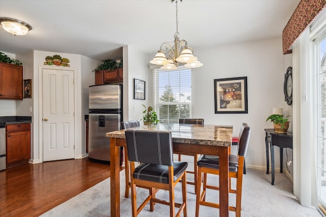 dining room with dark wood-style flooring, baseboards, and an inviting chandelier