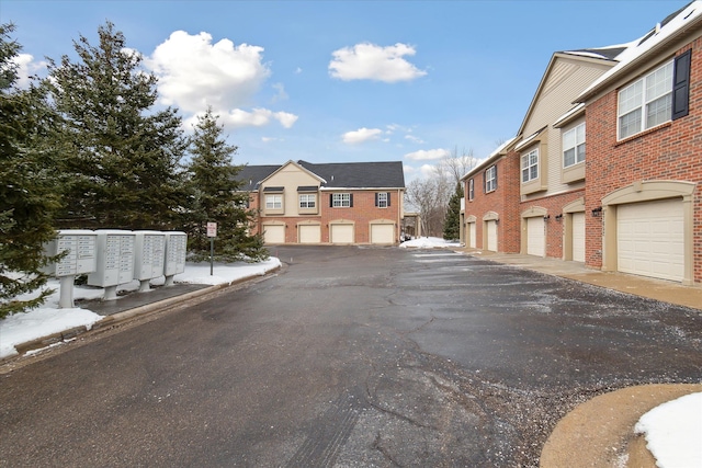 view of street with curbs, a residential view, and community garages