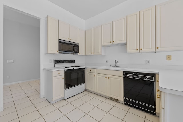 kitchen featuring light tile patterned floors, light countertops, a sink, black appliances, and baseboards