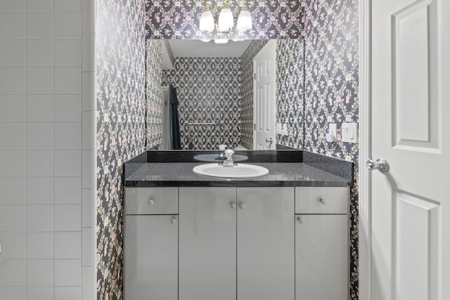 bathroom with vanity and wallpapered walls