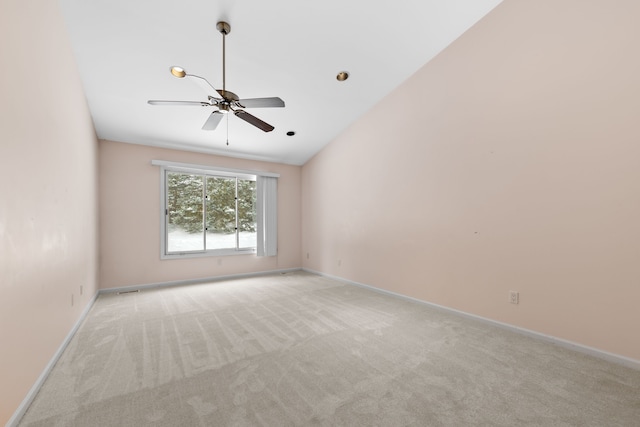 spare room featuring light carpet, baseboards, a ceiling fan, and lofted ceiling