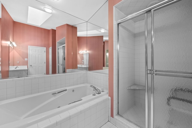 bathroom with a whirlpool tub, a skylight, a shower stall, and vanity