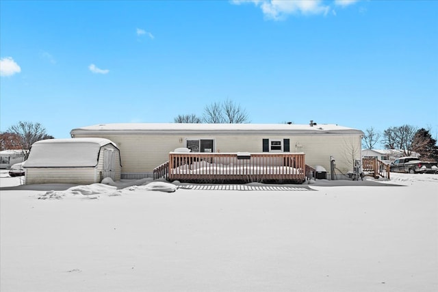 snow covered property with a wooden deck