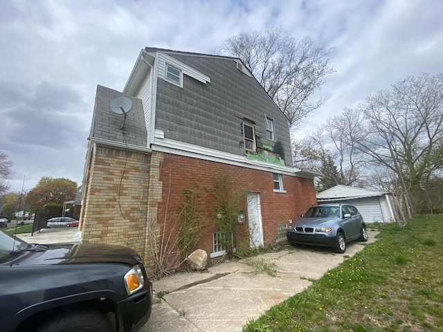 view of property exterior featuring driveway and brick siding