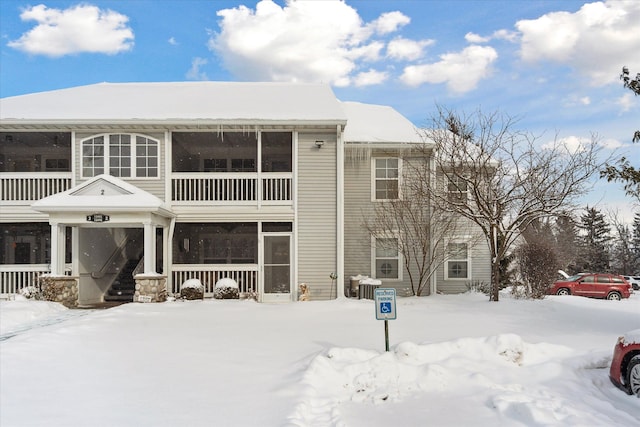 view of snow covered back of property