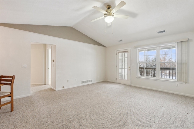 empty room featuring lofted ceiling, ceiling fan, light carpet, and visible vents